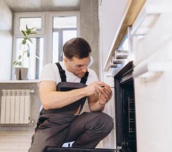 plumber-repairing-oven-in-modern-kitchen-photo